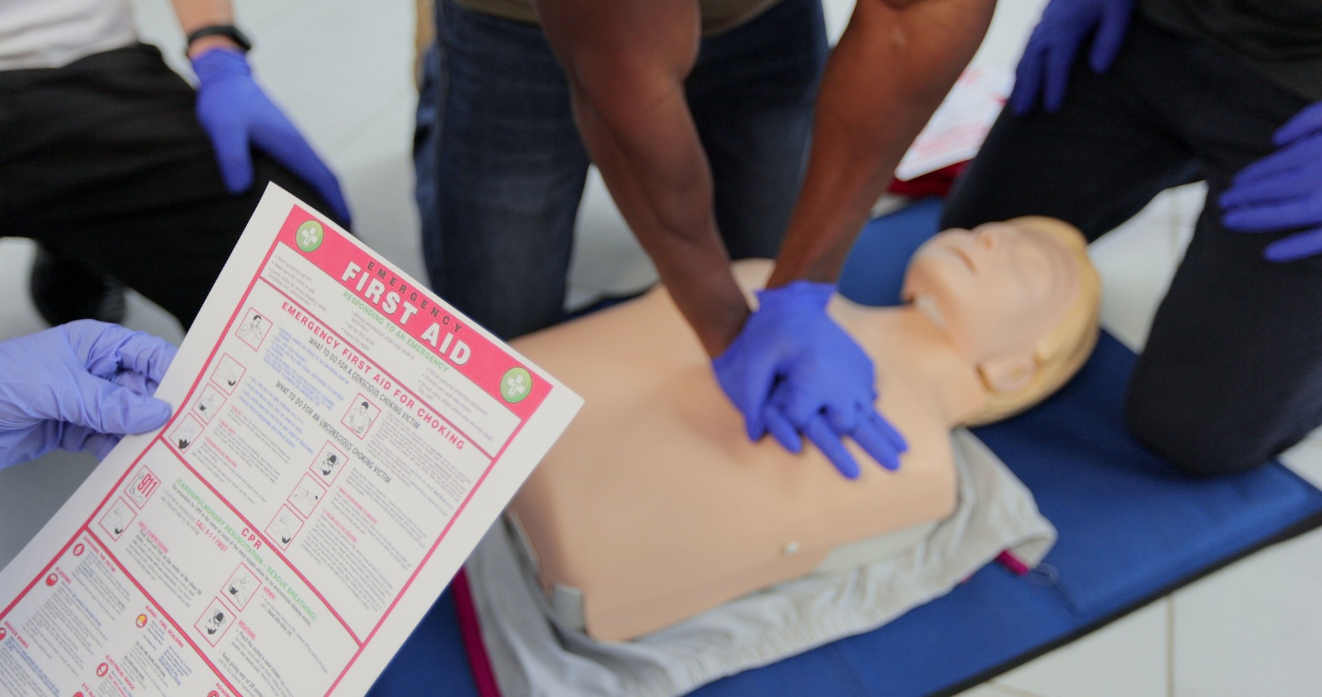 CPR First Aid training concept. Back view of woman holding first aid instruction during cpr training class. CPR First Aid training concept. Back view of woman holding first aid instruction during cpr training class.